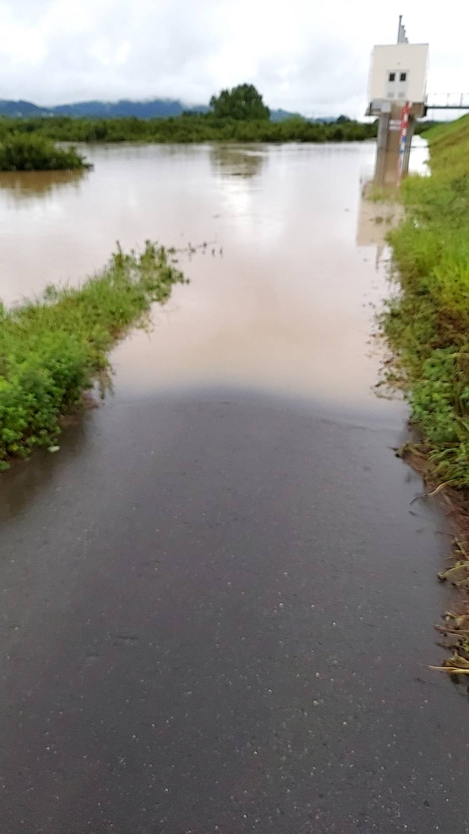 大雨で川の水が入っている道路